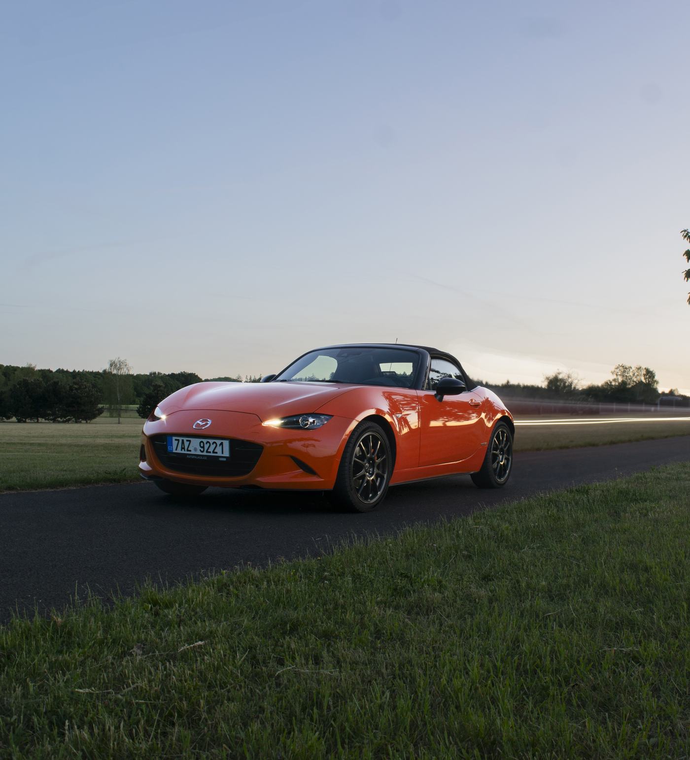 Mazda MX-5 na silnici za soumraku